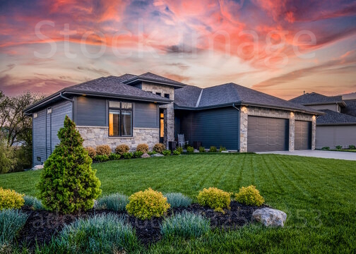 Well-maintained home at sunset with landscaped lawn